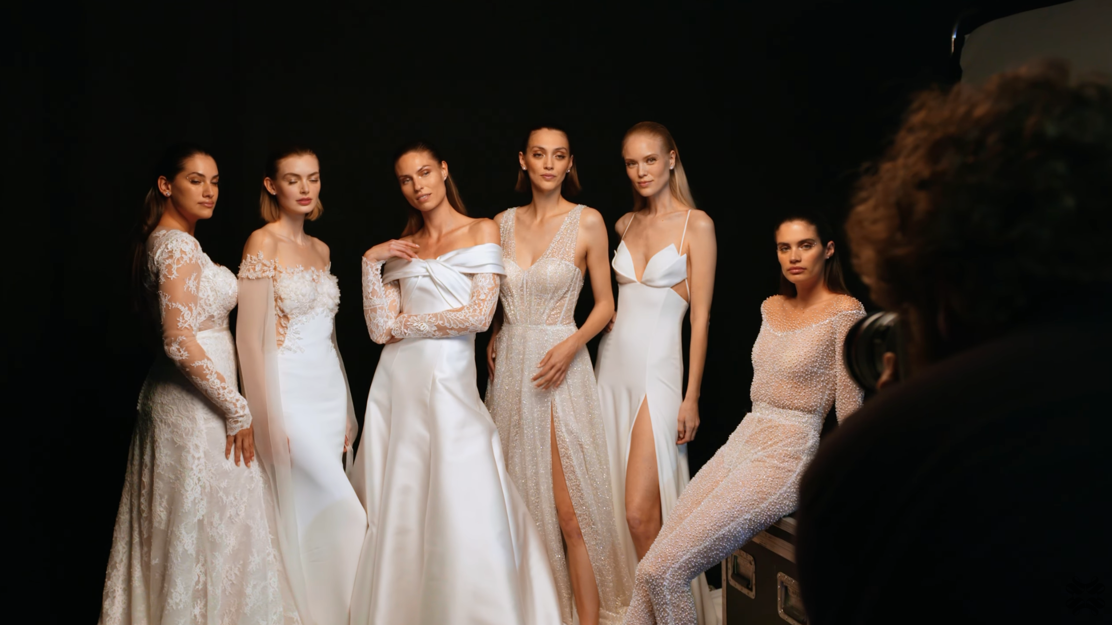 six models posing wearing wedding dresses and hair extensions being photographed